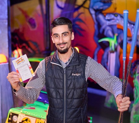 A young man in The Light uniform welcoming you to play mini golf