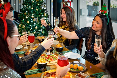 A merry throng enjoying Christmas food and drinks