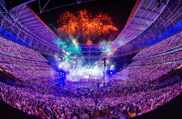 Will Champion of Coldplay performs on stage at Wembley Stadium